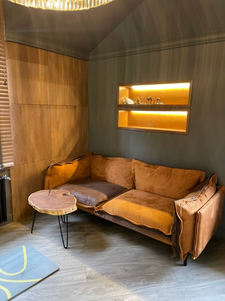 Plush brown sofa and rustic coffee table in a cozy, wood-paneled room.